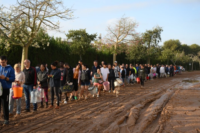 La gente hace cola para recoger agua después de las inundaciones que azotaron gran parte de Valencia, España