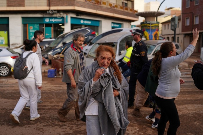 Una mujer reacciona en una calle cubierta de barro tras las mortales inundaciones en el barrio de De La Torre de Valencia, en el este de España.