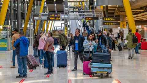 Los pasajeros se encuentran con el equipaje en la sala de salidas del aeropuerto de Madrid Barajas.