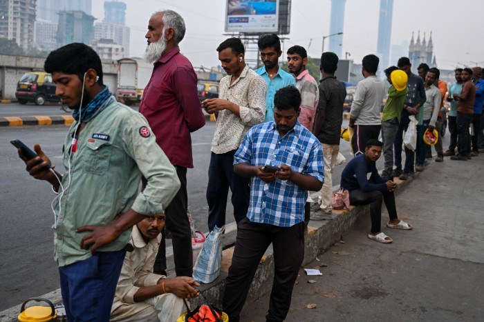 Trabajadores asalariados esperan trabajo en Mumbai