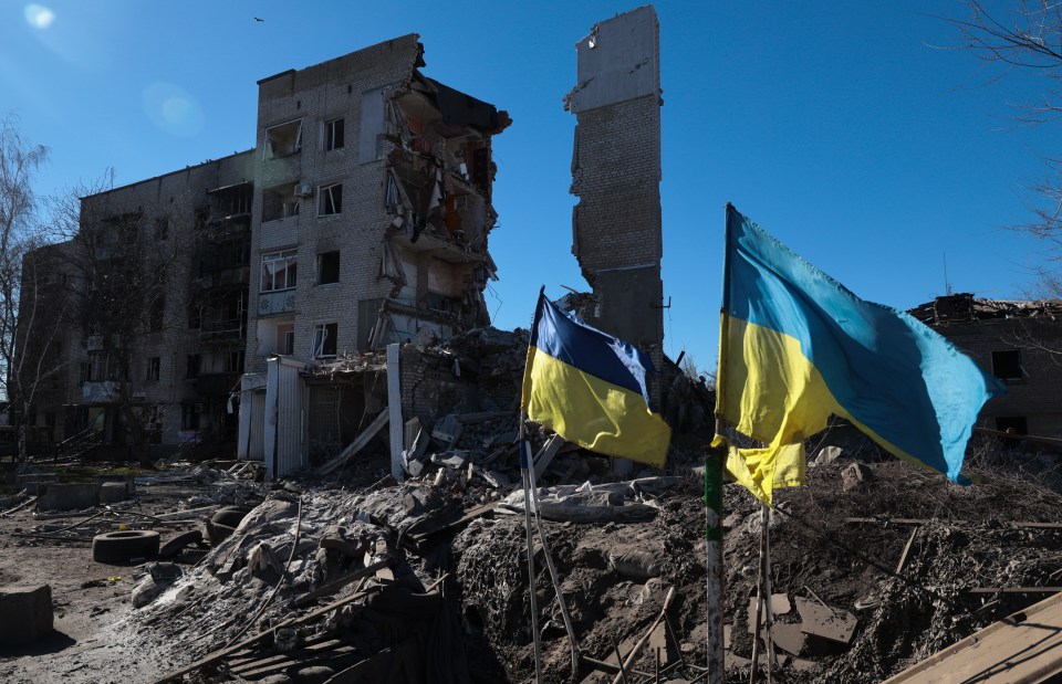 Banderas ucranianas ondean frente a edificios residenciales dañados en Orikhiv, cerca de la línea del frente en la región de Zaporizhzhia, Ucrania