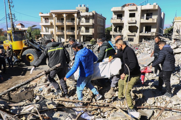 Los equipos de rescate retiran el cuerpo de un oficial de defensa civil del lugar de un ataque aéreo israelí contra una instalación de defensa civil en la aldea oriental de Douris.