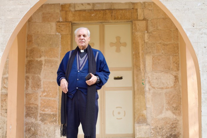 El padre Marwan Maalouf frente a la iglesia de Santa Bárbara 