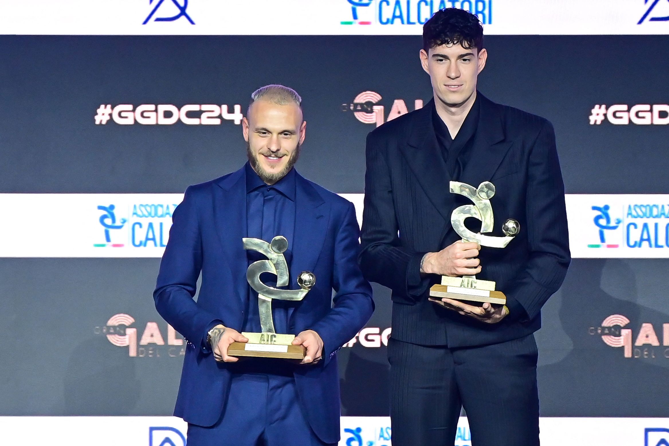 (LR) Los defensores italianos del Inter de Milán, Federico Dimarco y Alessandro Bastoni, posan en el escenario después de recibir el premio al Mejor Defensor del Año durante la gala y ceremonia de entrega de premios de la Asociación Italiana de Futbolistas (AIC) en Milán, el 2 de diciembre de 2024. (Foto de Piero CRUCIATTI / AFP)