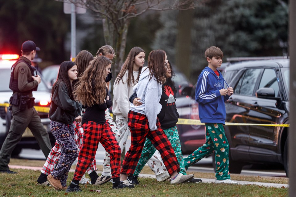 Familias consolándose mutuamente fuera de la escuela