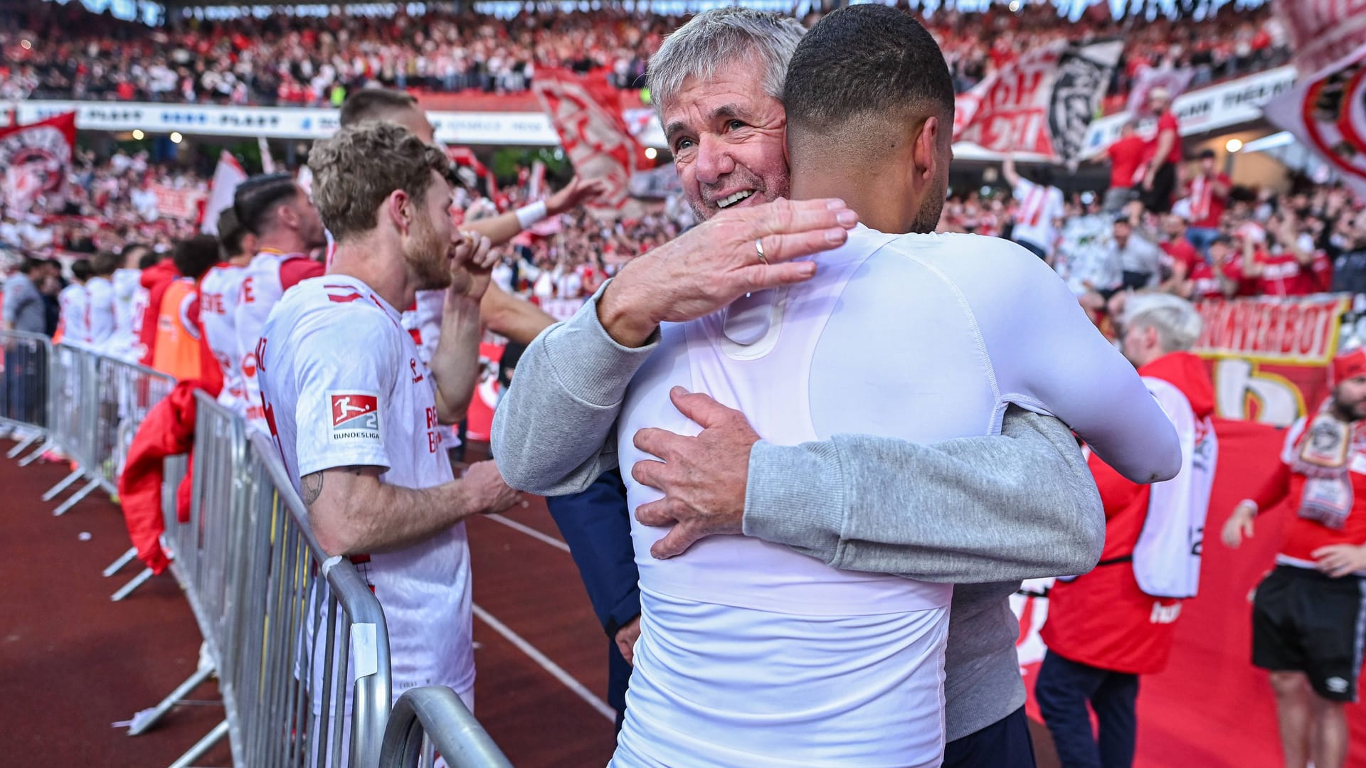 El nuevo entrenador Friedhelm Funkel abraza a Linton Maina después de la victoria de Away.