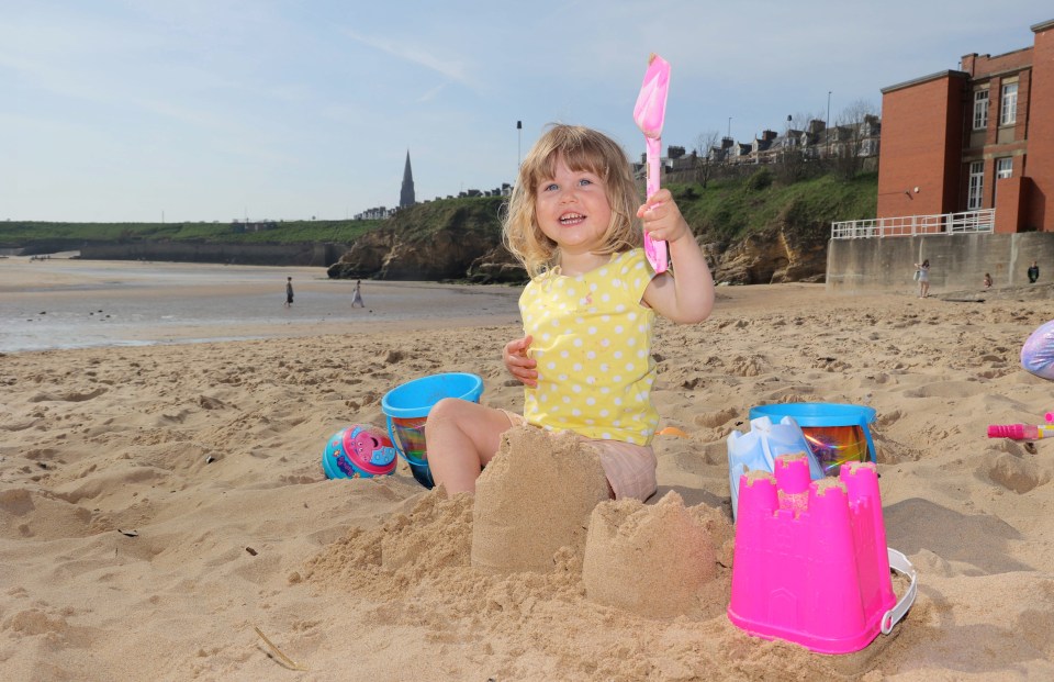 Partidos de arena de edificios para niños pequeños en una playa.