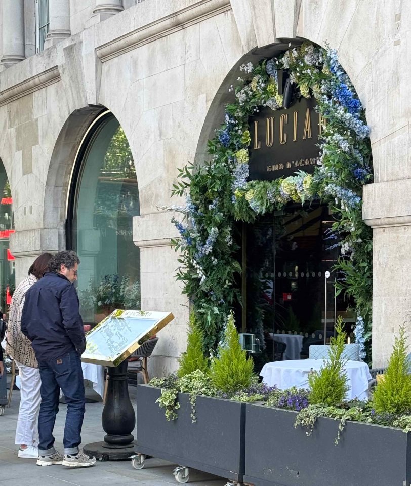 Exterior de Lucía del restaurante Gino d'Acampo en Londres, con dos personas mirando un menú.