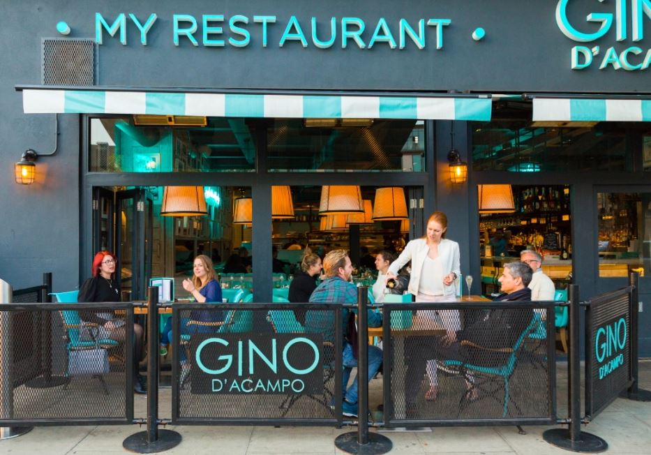 Exterior de restaurante Gino D'Acampo con clientes que cenan afuera.
