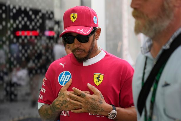 Lewis Hamilton camina por el paddock de F1 con un polo Ferrari