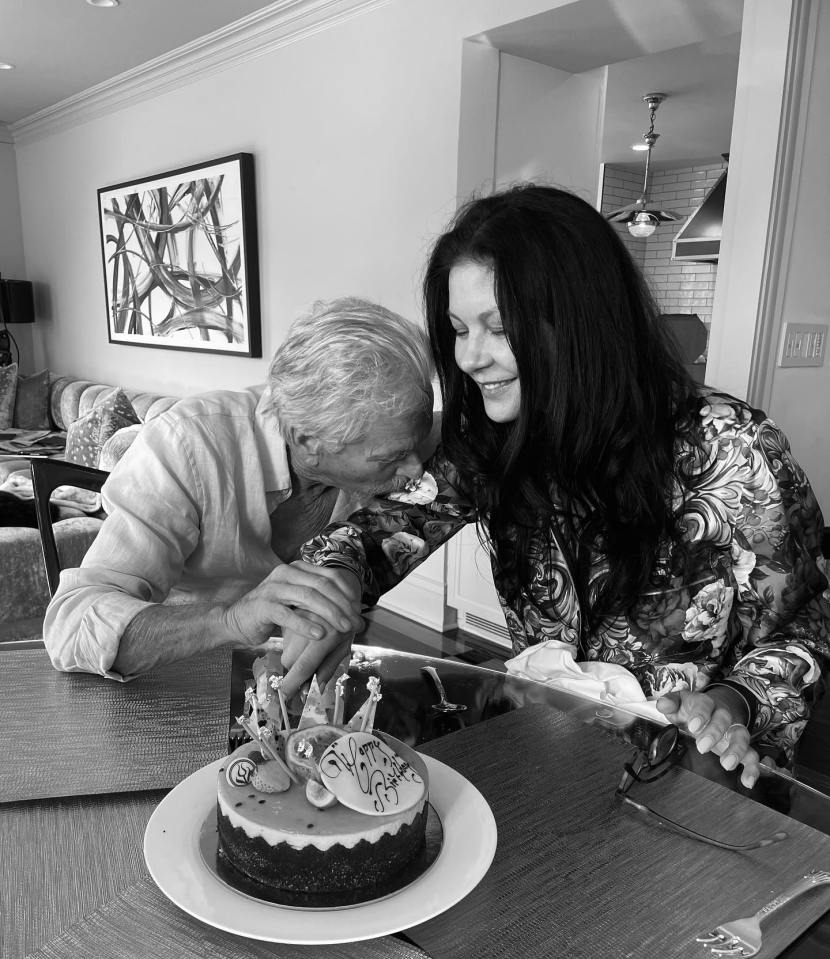 Una foto en blanco y negro de un hombre y una mujer cortando un pastel de cumpleaños