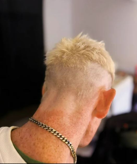 Persona con cabello rubio, corto y puntiagudo.