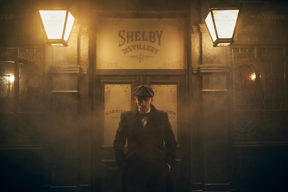 Arthur Shelby de pie afuera de Shelby Distillery.