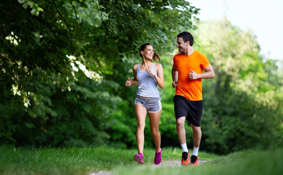 Feliz pareja corriendo al aire libre.