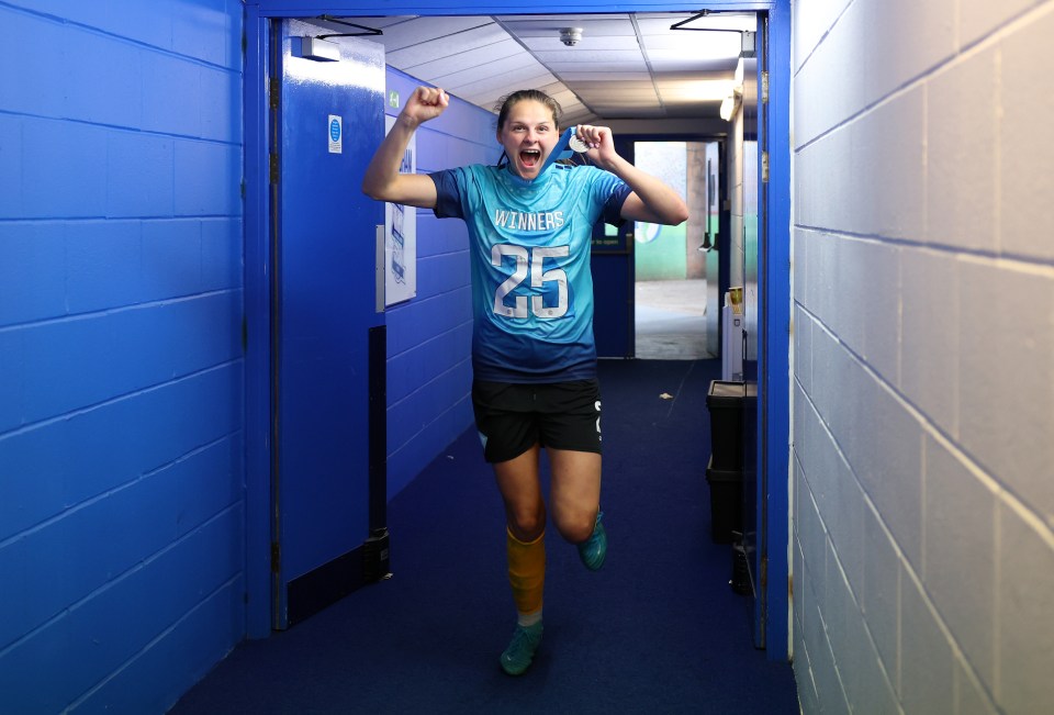 Un jugador de fútbol jubiloso celebra una victoria en un túnel.
