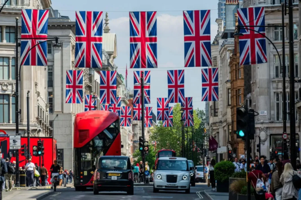 Escena callejera en Londres con banderas de Union Jack colgando por encima.