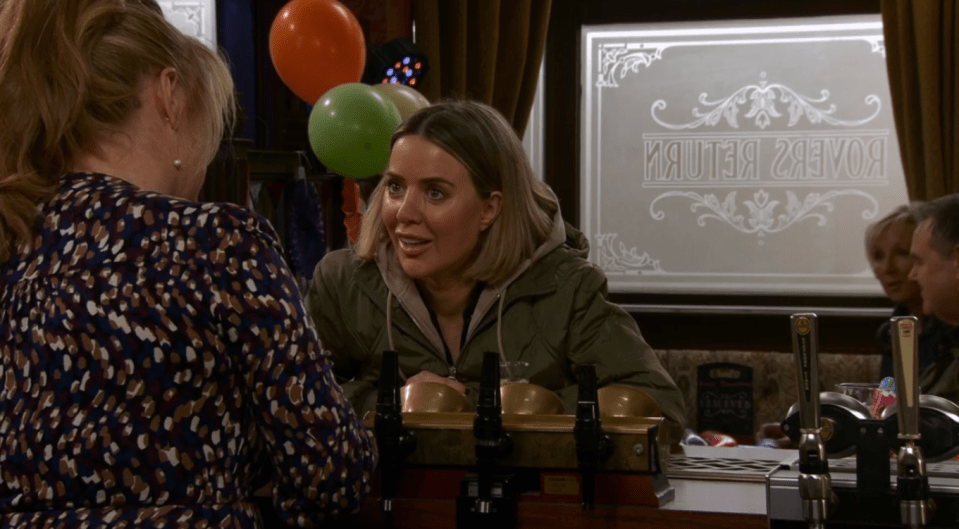 Captura de pantalla de dos mujeres que hablan en un bar con globos en el fondo.