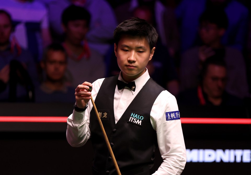 Zhao Xintong de China se prepara para un disparo de billar.