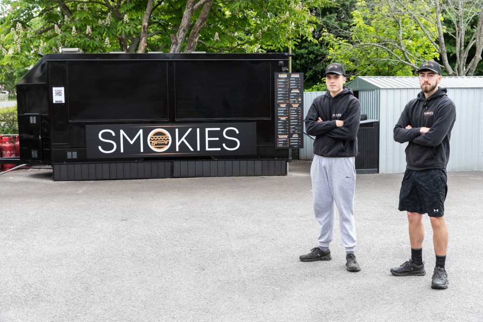Dos hombres se paran frente a su Van de hamburguesa Smash cerrada, Smokies.