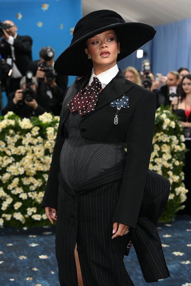 Rihanna en la Gala Met con un traje de rayas negras y un sombrero de ala ancha.