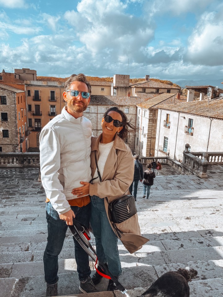 Emma Kemsley y su esposo James en una escalera, con una ciudad en el fondo.