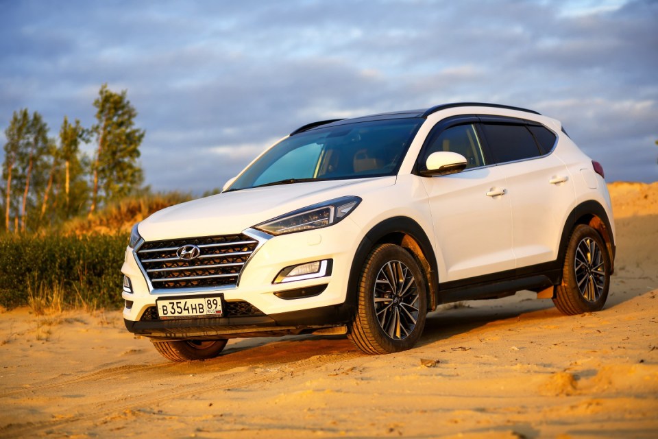 Hyundai Tucson blanco sobre una superficie arenosa.
