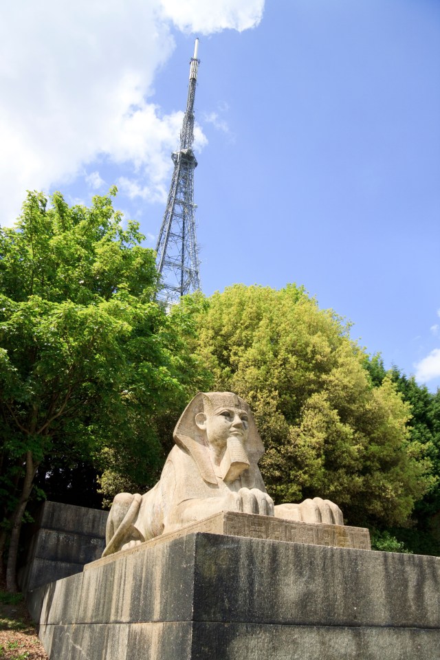 Sphinx de piedra con una torre del transmisor de televisión en el fondo.