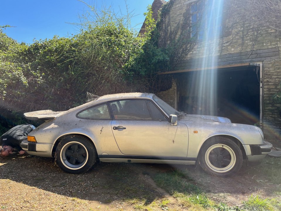 Dusty Silver 1989 Porsche 911 Carrera Sport Coupe en un garaje.