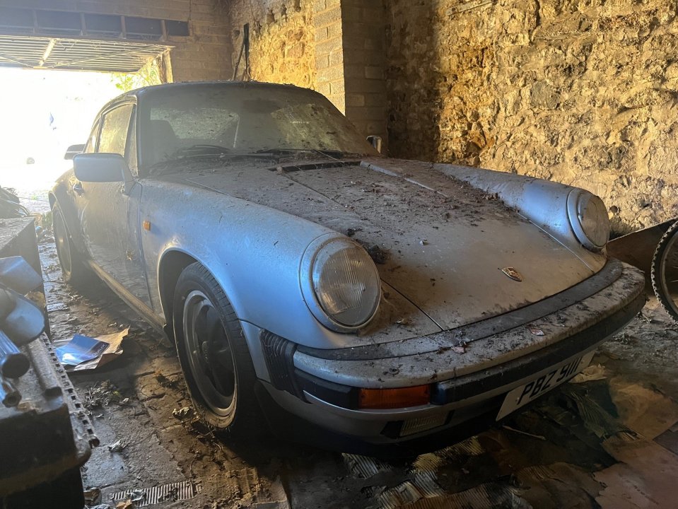 Dusty Porsche 911 Carrera en un garaje.