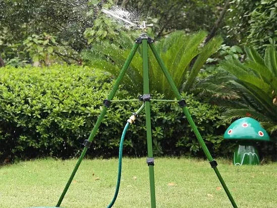 Trípode rociador de césped que rocía agua.