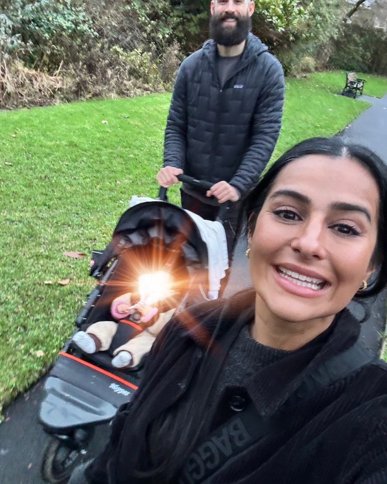 Familia caminando a un bebé en un cochecito.
