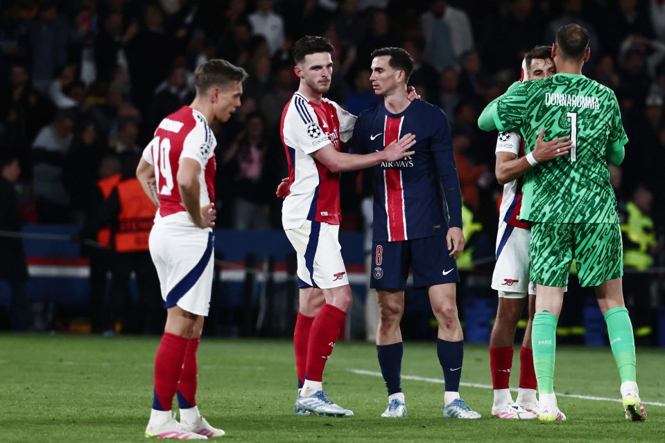 Un jugador de PSG consuela a un jugador del Arsenal después de un partido de la Liga de Campeones.