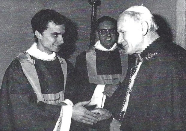 Foto en blanco y negro del Papa Juan Pablo II dando la mano con el reverendo recién ordenado Robert Francis Prevost.