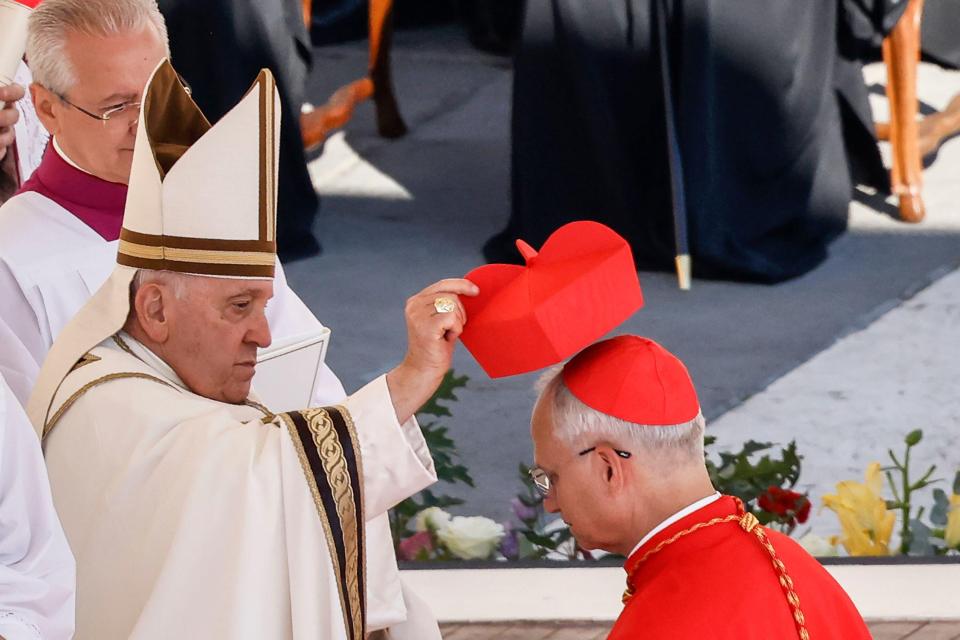 Papa Francisco colocando una biretta roja en la cabeza de un nuevo cardenal.
