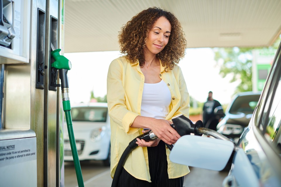Mujer bombeando gas en su auto.