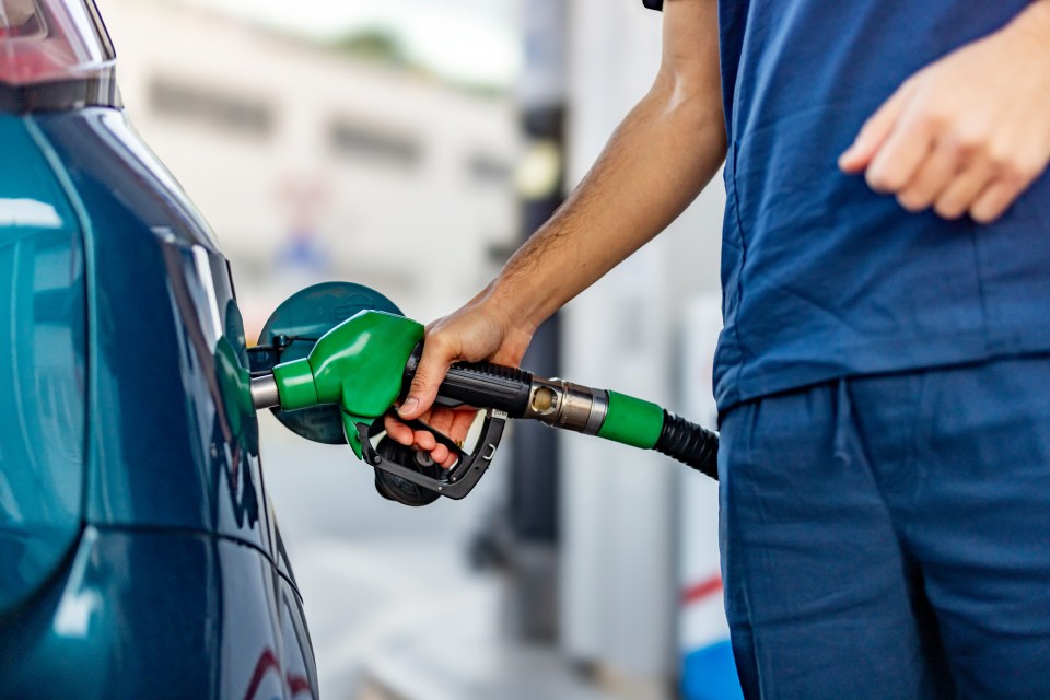 Joven reabasteciendo su auto moderno en la estación de gasolina