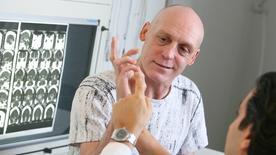 Un neurocirujano verifica las habilidades motoras de las manos en un paciente de accidente cerebrovascular.