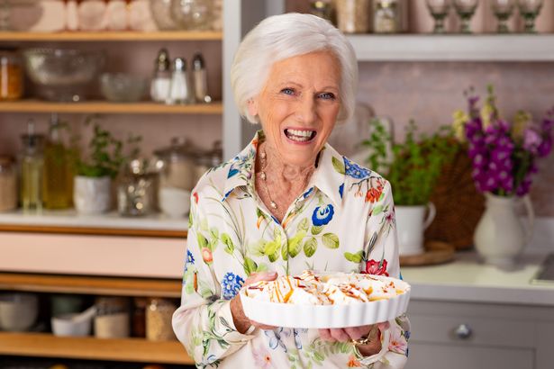 Mary Berry sonriendo en la cocina sosteniendo un plato de comida
