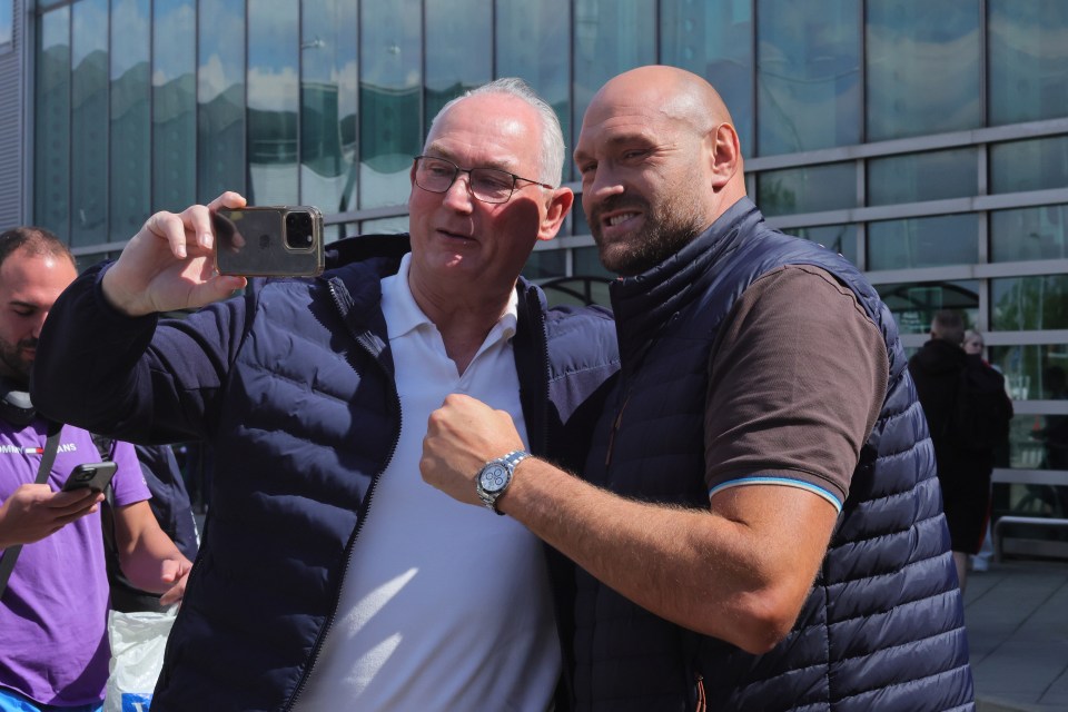 Tyson Fury y su padre se toman una selfie en un aeropuerto.