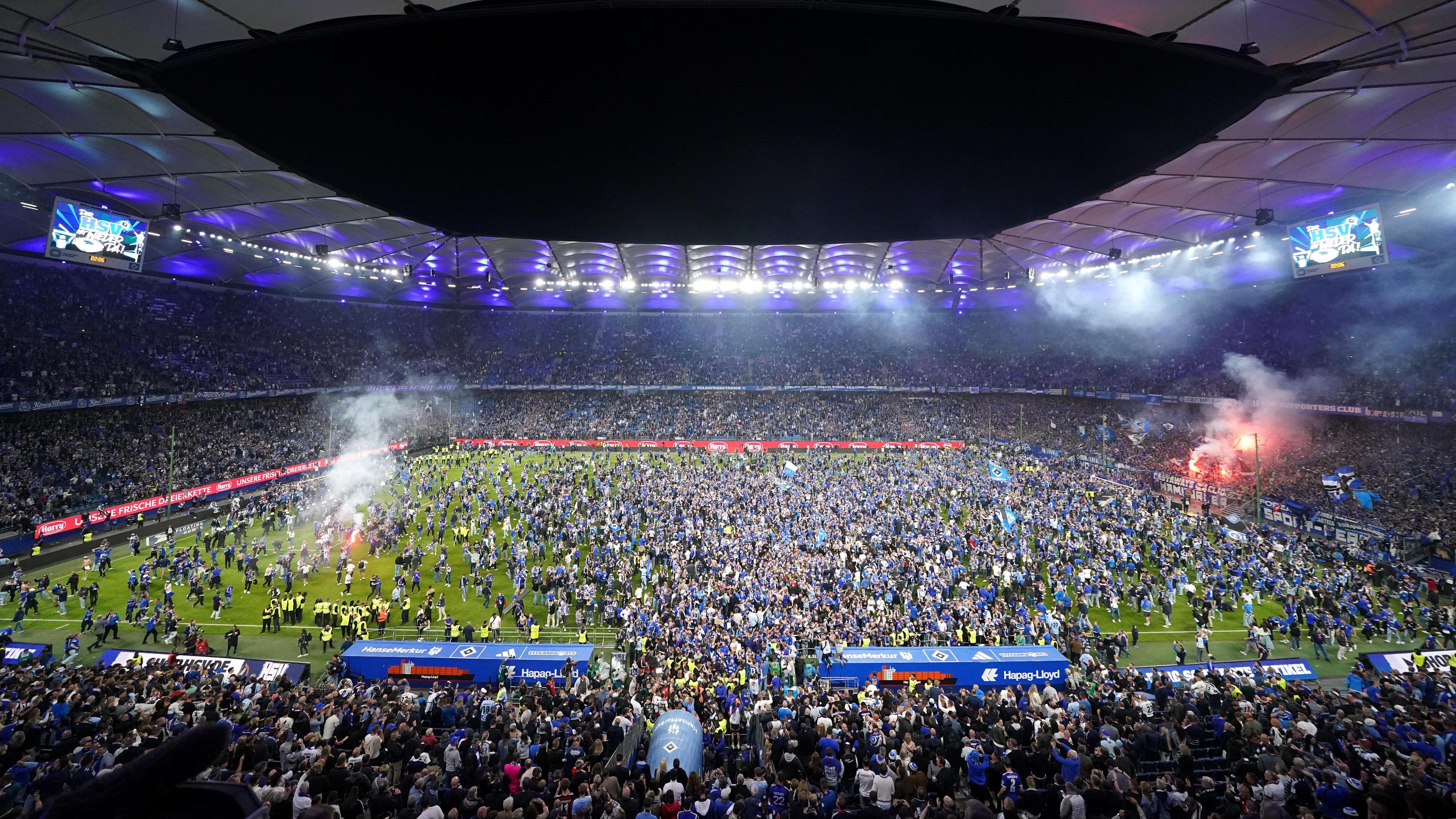 Los fanáticos de Hamburgo asaltan el césped después del juego y celebran la promoción de la primera Bundesliga.