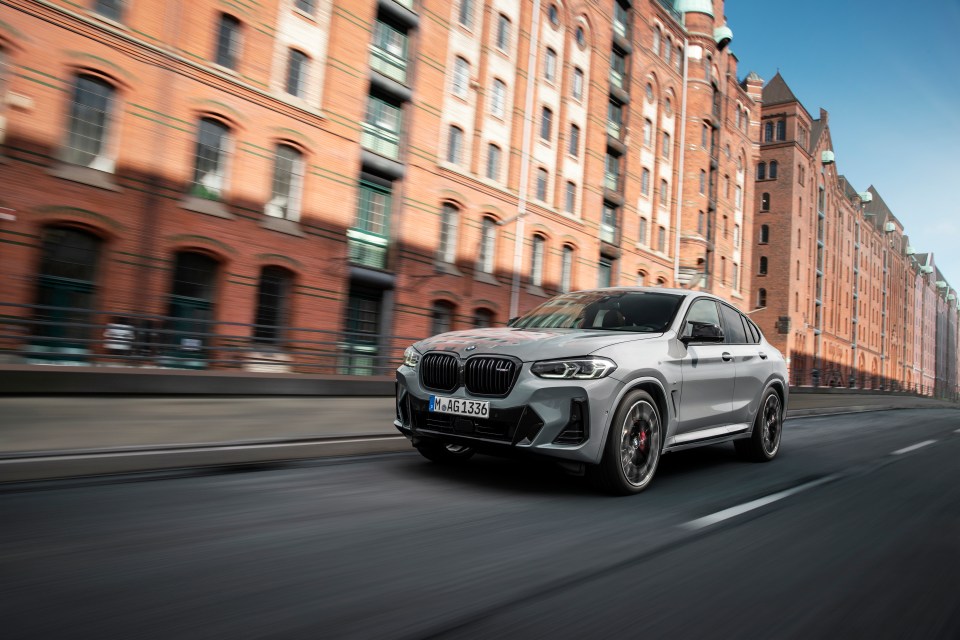 Silver BMW X4 conducir en City Street.