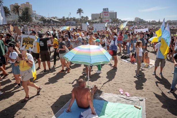 Los manifestantes marchan en Las Americas Beach durante una manifestación para protestar contra el turismo de masas, en Arona en la isla canaria española de Tenerife, el 20 de octubre de 2024. 