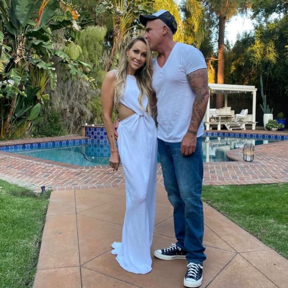 Tish Cyrus y Dominic Purcell por una piscina.
