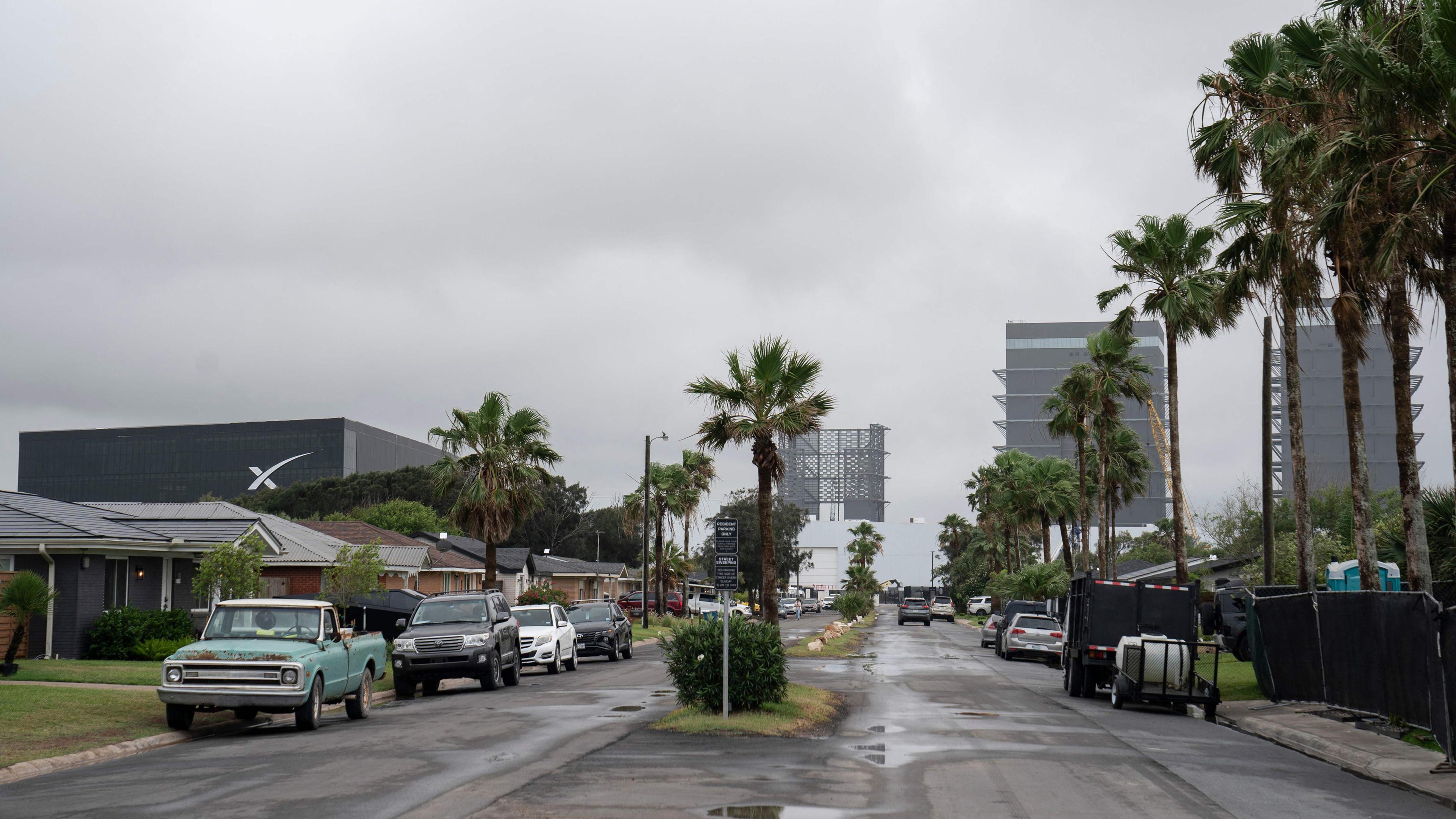 Calles, autos, rascacielos y palmeras en el vecindario cerca de SpaceX.