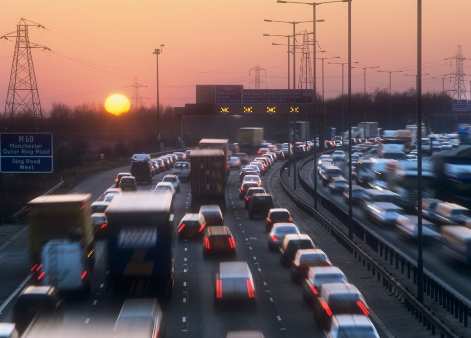 Tráfico de la hora pico en una carretera de varios carriles al atardecer.