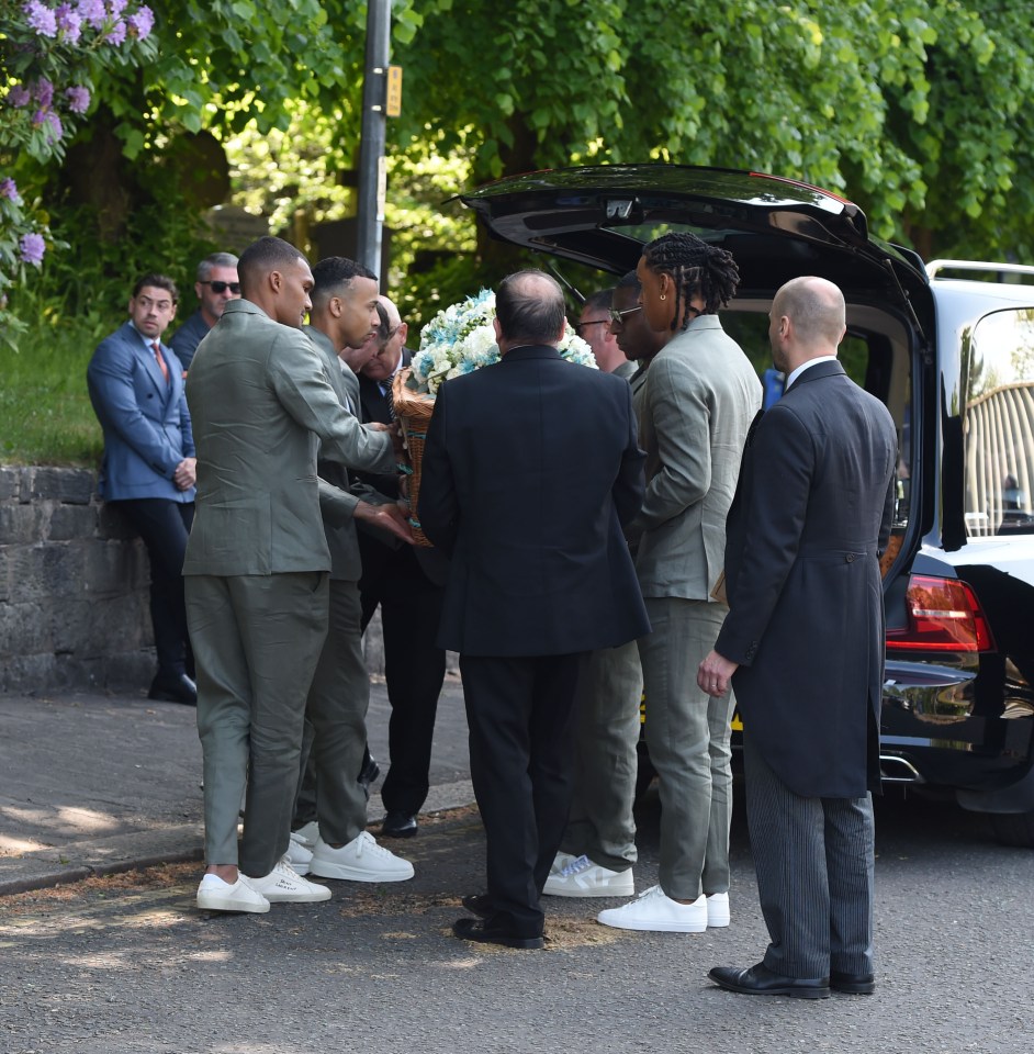 Los portadores que llevan un ataúd en un funeral.
