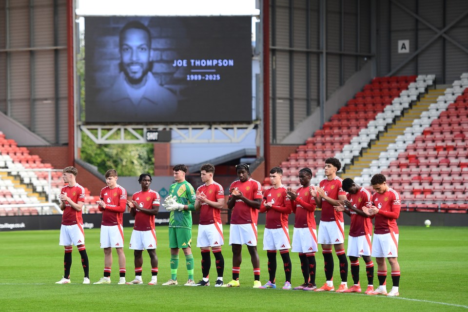 Los jugadores del Manchester United observan un momento de aplausos.