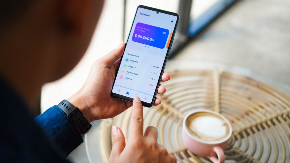 Persona revisa su cuenta bancaria en línea en un teléfono inteligente.
