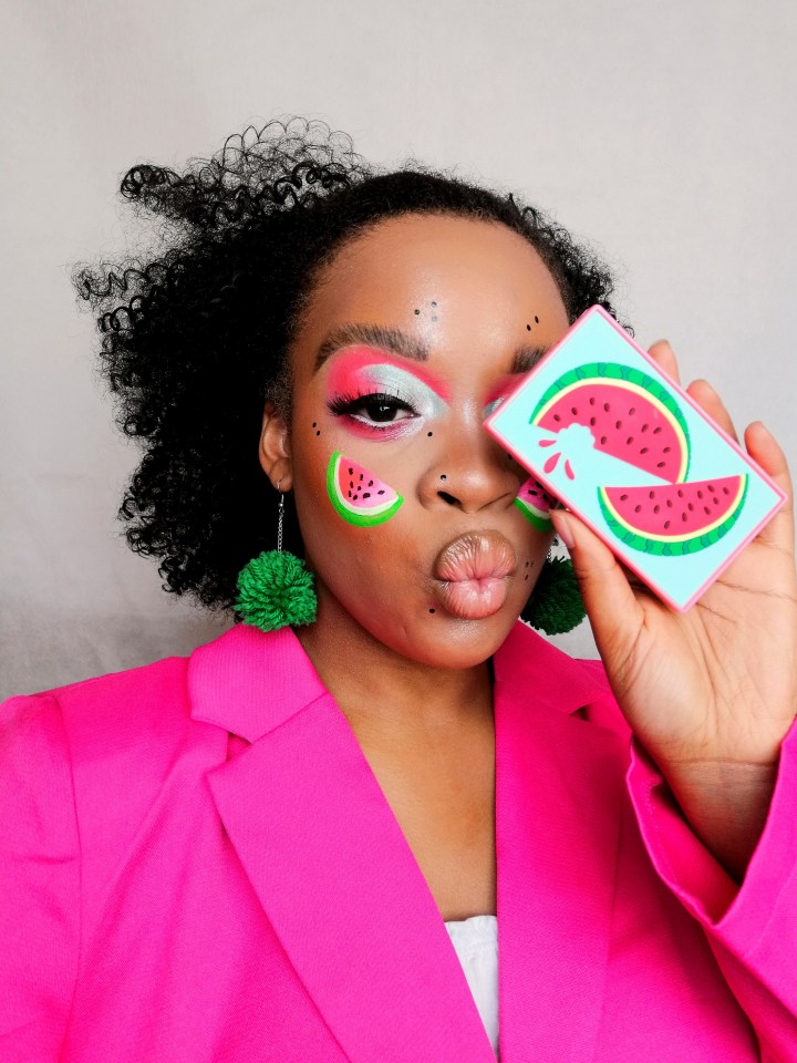 Mujer con maquillaje de sandía y un compacto temático de sandía.