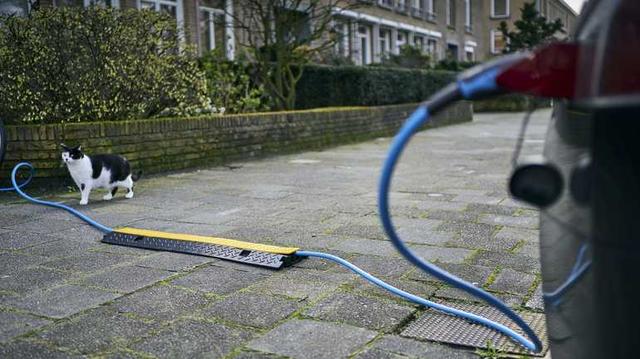 Cargando un automóvil eléctrico con cable sobre la acera a